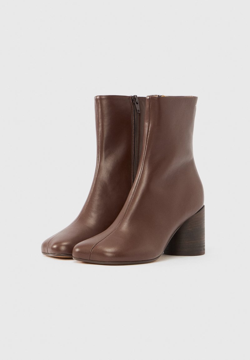 Brown leather ankle boots with a smooth finish, front zipper, rounded toe, and a chunky wooden heel.