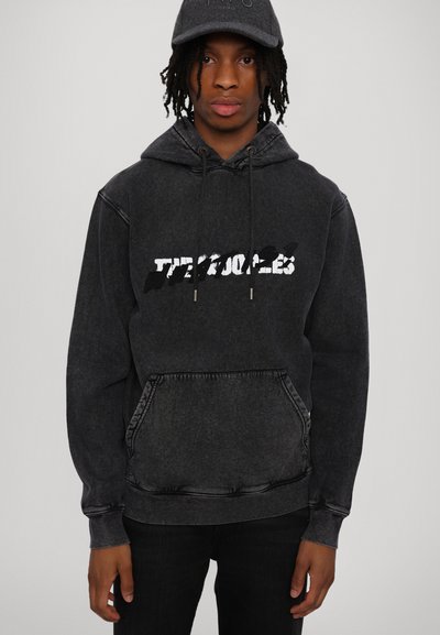 Black denim hoodie with a front pocket, drawstring hood, and white graphic text. Material appears soft with a slightly worn texture.