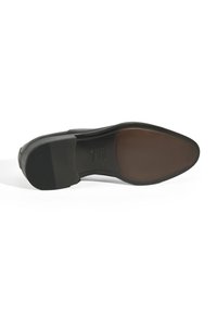 Semelle de chaussure en cuir noir avec un insert lisse marron et une section texturée et striée au niveau du talon. Design épuré, construction plate.