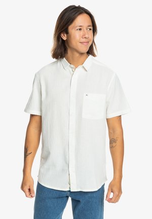 White short-sleeve shirt with a pocket, made from textured fabric. Features a button front and subtle brand detail above the pocket.