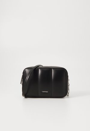 Crna kožna torba na rame pravokutnog oblika, sa podstavljenom teksturom, srebrnim dijelovima i Calvin Klein logotipom sprijeda.