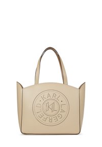 Bézs bőr válltáska dupla fogantyúval és elöl perforált kör alakú logóval.