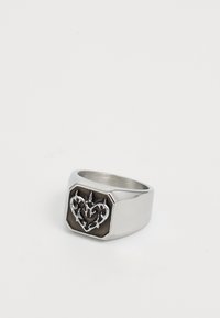Silberner Ring mit einer schwarzen rechteckigen Fläche, die in der Mitte ein erhabenes, kunstvolles Herzdesign aufweist.