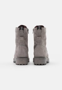 Bottes chelsea en suede gris avec une finition texturée, dotées d'une fermeture éclair sur le côté, d'accents de talon rayés et d'un intérieur rembourré.
