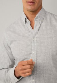 Hemd mit Knopfleiste in Hellgrau mit einem geometrischen Muster, langen Ärmeln und klassischem Kragen. Verfügt über eine Knopfleiste und verstellbare Manschetten.