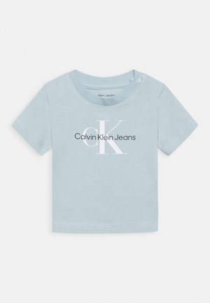 T-shirt bébé bleu clair à manches courtes avec le logo Calvin Klein Jeans en lettres blanches et noires sur le devant et des boutons pression à l'épaule.