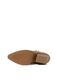 Stivale beige con tacco, upper testurizzato, punta quadrata e suola in gomma con scanalature orizzontali per una migliore aderenza.