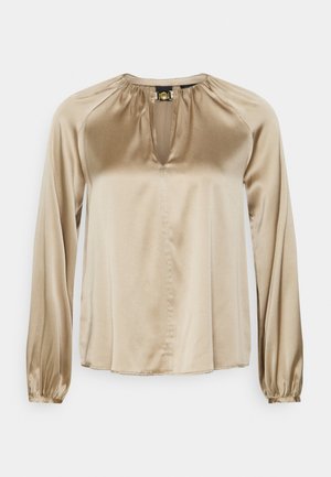 Beige Satinbluse mit langen Ärmeln, gerafftem Ausschnitt, Schlitz vorne und kleinem goldfarbenem Schmuckverschluss am Kragen.