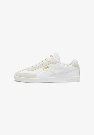 Zapatillas blancas de cuero y gamuza con un logo dorado. Presentan una puntera redonda, un diseño plano de cordones y una suela de goma texturizada.