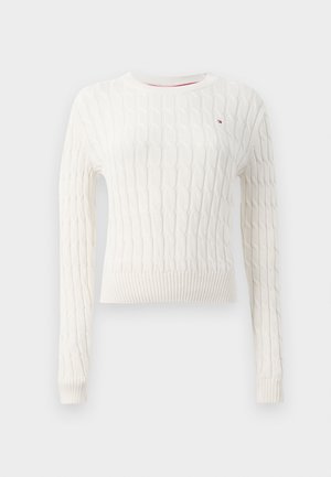 White cable-knit sweater with a crew neckline, ribbed cuffs, and hem. Features textured pattern and a small logo on the chest.