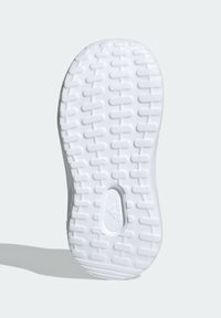 Biała gumowa podeszwa sneakersa z fakturowanym wzorem z małymi prostokątnymi uchwytami i owalnym wycięciem, oznaczona marką "adidas".