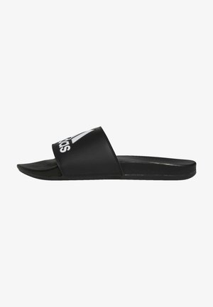 Black slide sandals with a wide strap featuring a white logo. Made of synthetic material, they have a flat sole and smooth texture.