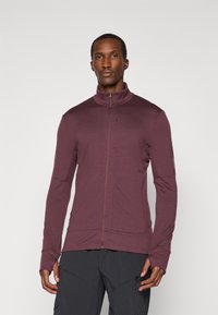 Jachetă zip-up maron cu guler înalt și mâneci lungi. Prezintă cusături plate și buzunare laterale, fabricată dintr-un material texturat și flexibil.