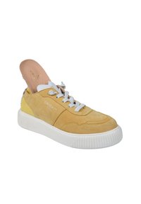 Gelber Wildledersneaker mit weißen Schnürsenkeln, einer weißen Gummisohle und einer zum Teil herausgenommenen beigen Innensohle, seitlich mit "CRICKIT" gebrandet.