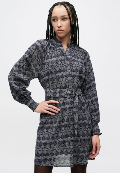 Φόρεμα σε ναυτικό μπλε με σχέδιο καρδιές, μακριά μανίκια, κουμπωτό γι�ακά και δετή μέση. Κατασκευασμένο από ελαφρύ, υφασμάτινο ύφασμα με υφή.