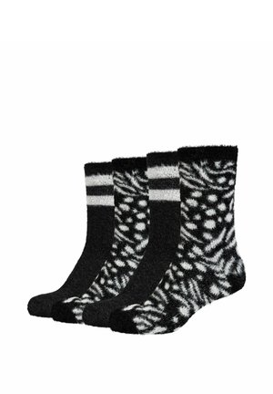 Vier schwarz-weiße flauschige Sneakersocken, paarweise angeordnet, mit gestreiften und gesprenkelten abstrakten Mustern.