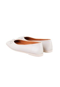 Witte leren balletschoenen met een ronde neus, voorzien van een delicaat strikaccent en een platte zool. De binnenkant is tan-kleurig.