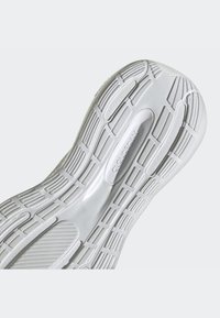 Shoe sole in white rubber with textured grip patterns and smooth sections, featuring a central logo that reads "CLOUDFOAM."