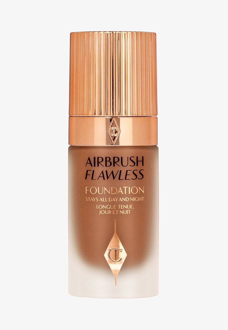 Airbrush Flawless foundation in a sleek glass bottle with a ridged, metallic gold cap and brown gradient finish, featuring embossed logo and text.
