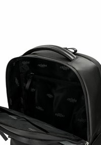 Černý batoh otevřený, aby ukázal vnitřní kapsu na zip a látkovou podšívku s logy „relaks“, vybavený polstrovanou rukojetí na vrchu.