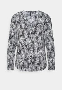 Sort-hvid nederdel med lange ærmer og V-hals, med et tekstureret mønster af prikker og kruseduller, lavet af let stof.