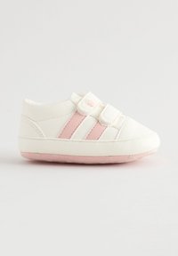 Baskets bébé blanches avec des rayures roses, deux bandes velcro et une semelle rose sur un fond clair uni.
