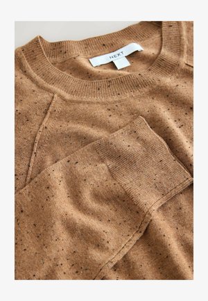 Pull tricot marron avec un col rond côtelé, présentant des motifs tachetés noirs sur toute la surface. Texture lisse, design décontracté, étiquette visible.