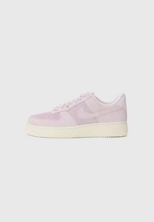 Baskets Nike Air Force 1 en suède violet clair avec semelle crème, logo swoosh latéral et lacets, présentées sur un fond blanc uni.