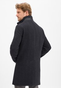 Dunkelgrauer Wollmischungs-Mantel mit einem strukturierten Schnitt, der einen schwarzen Lederkragen und eine glatte Textur aufweist, entworfen für eine moderne Silhouette.