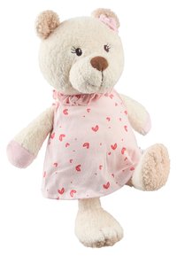 Un ourson en peluche crème douce portant une robe rose avec des cœurs rouges et un nœud rose sur une oreille, posé debout avec une patte levée.