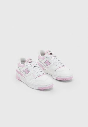 Para białych i jasnoróżowych sneakersów New Balance ze sznurówkami, logo po boku oraz z teksturowaną podeszwą, pokazana na jednolitym tle.