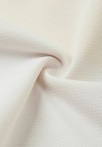 Weißer strukturierter Stoff mit einem feinen, gemusterten Gewebe, das eine weiche, elastische Qualität und eine glatte Oberfläche aufweist, in Falten drapiert.