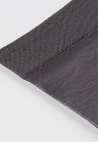 Svart elastisk tyg med en texturerad övre kant och en slät nederdel, med ren sömnad längs sömmarna och en matt finish.