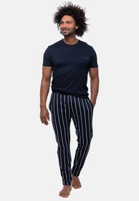 Marinblå bomullströja med bröstficka i kombination med marinblå och vita randiga pyjamabyxor. Byxorna har en tapered passform och elastisk midja.