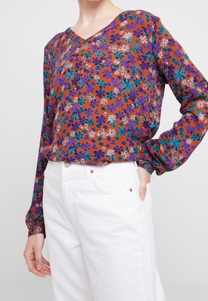 Multicolore bloes met bloemenpatroon en V-hals, met oranje, paars en teal tinten. Lange mouwen met manchetten en lichte stof.