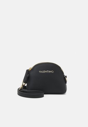 Malá černá Valentino kabelka na zápěstí se zlatým zipem a logem, strukturovaný půlměsícový tvar a odnímatelný popruh na bílém pozadí.