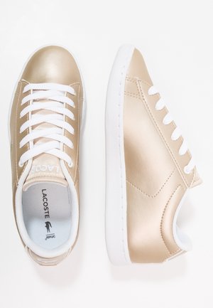 Gouden synthetische sneakers met witte veters en zool, voorzien van een gladde afwerking, ronde neus en logo op de tong en hiel.