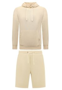 Beige hoodie met een voorzak en verstelbare trekkoorden, gecombineerd met bijpassende shorts met een elastische tailleband en trekkoord.