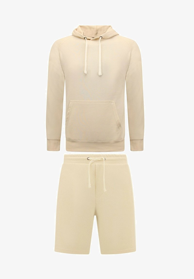 Beige hoodie met een voorzak en verstelbare trekkoorden, gecombineerd met bijpassende shorts met een elastische tailleband en trekkoord.
