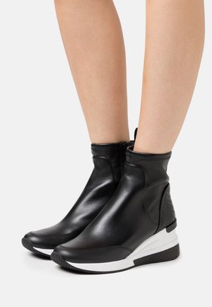 Schwarze Leder-Stiefeletten mit strukturiertem hinteren Teil, weißer Sohle und glatter Oberfläche. Mit einem seitlichen Reißverschluss und elastischen Akzenten.