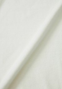 Valkoinen puuvillakangas, jossa on pehmeä tekstuuri, hienovarainen ribbineuloskuvio ja tasainen laskeutuvuus, ihanteellinen vaatteisiin ja tekstiileihin.