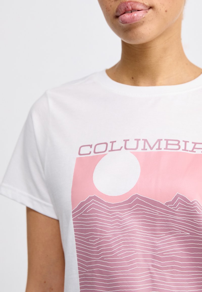 Weißes Baumwoll-T-Shirt mit einem pinken Grafikdesign, das Bergkonturen und eine große Sonne zeigt, runder Halsausschnitt und kurze Ärmel.
