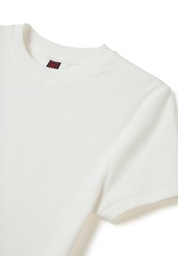 Camiseta blanca de canalé con cuello redondo y mangas cortas. Presenta un tejido texturizado con un detalle de costura visible.