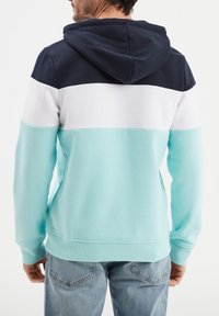 Bluza z kapturem w kolorystycznym bloku w odcieniach granatowym, białym i miętowym, o miękkiej teksturze i ściągaczach przy mankietach i dolnym brzegu.