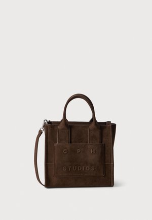 Sac à main en daim brun foncé avec deux poignées, bandoulière amovible et poche avant embossée avec le lettrage "CPH STUDIOS".