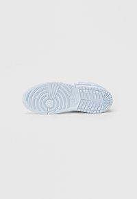 Σόλα αθλητικού παπουτσιού γαλάζιου χρώματος με υφή λαβής, που περιλαμβάνει στρογγυλεμένα και γωνιώδη σχέδια, καθώς και έναν κυκλικό έμβλημα κοντά στη φτέρνα.