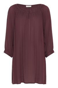 Blouse bordeaux en tissu léger et légèrement transparent. Présente un col rond, des manches 3/4 et des détails froncés autour du cou.