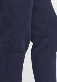 Merenväriset joggerit pehmeästä kankaasta, joissa on slim fit -leikkaus, ommellut saumat ja huomaamaton sivutasku käytännöllisyyttä varten.