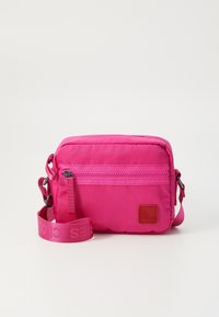 Borsa a tracolla rosa in nylon con una tasca frontale con zip, tracolla regolabile e una patche in tessuto logo. Forma rettangolare compatta.