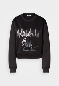 Sweatshirt cropped preto com uma estampa gráfica de uma figura a andar com uma bolsa contra o horizonte da cidade. Textura lisa, gola redonda.